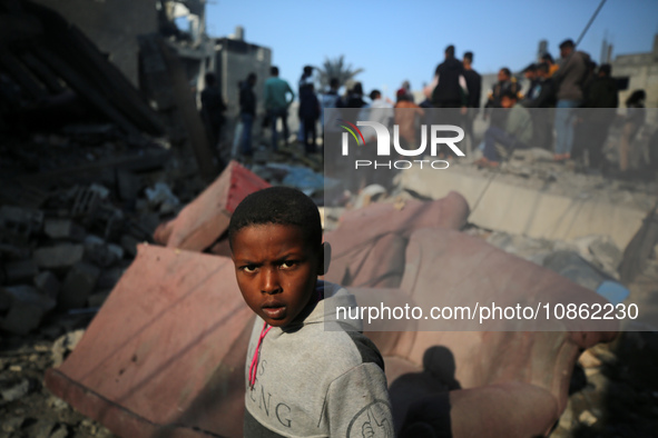 Palestinians are gathering amid the rubble of destroyed buildings following an Israeli bombardment in Deir El-Balah, in the central Gaza Str...