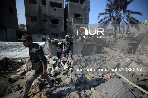 Palestinians are gathering amid the rubble of destroyed buildings following an Israeli bombardment in Deir El-Balah, in the central Gaza Str...