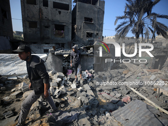 Palestinians are gathering amid the rubble of destroyed buildings following an Israeli bombardment in Deir El-Balah, in the central Gaza Str...