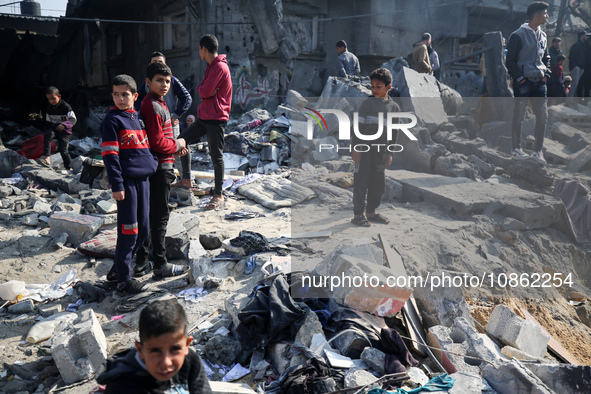 Palestinians are gathering amid the rubble of destroyed buildings following an Israeli bombardment in Deir El-Balah, in the central Gaza Str...