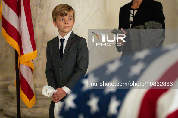 A young boy looks at the flag-draped  asker of Retired Associate Justice Sandra Day O’Connor, the first woman to serve on the Supreme Court,...