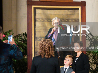 People interact with a portrait of retired Associate Justice Sandra Day O’Connor, the first woman to serve on the Supreme Court, as she lies...