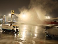 A staff member is driving China's self-developed ice removal mobile terminal system to de-ice the wing of a passenger plane's fuselage at th...