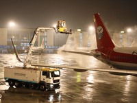 A staff member is driving China's self-developed ice removal mobile terminal system to de-ice the wing of a passenger plane's fuselage at th...