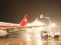 A staff member is driving China's self-developed ice removal mobile terminal system to de-ice the wing of a passenger plane's fuselage at th...