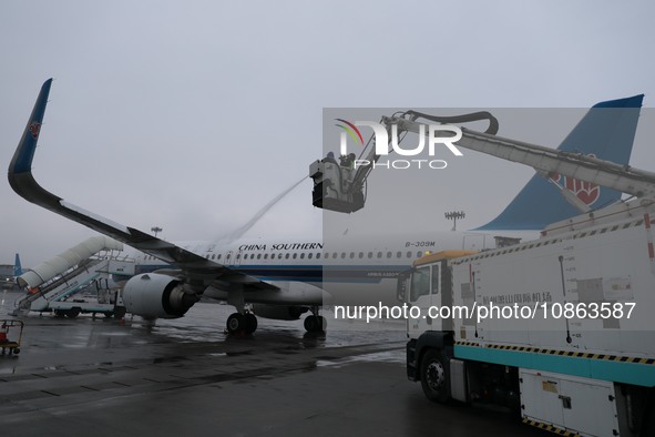 A staff member is driving China's self-developed ice removal mobile terminal system to de-ice the wing of a passenger plane's fuselage at th...