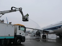 A staff member is driving China's self-developed ice removal mobile terminal system to de-ice the wing of a passenger plane's fuselage at th...