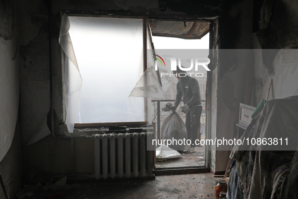 A man is picking up rubble in the apartment of Anatolii Luchok, which was damaged after the residential building at 4A Ostafiia Dashkevycha...