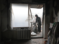 A man is picking up rubble in the apartment of Anatolii Luchok, which was damaged after the residential building at 4A Ostafiia Dashkevycha...