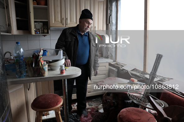 A man is standing inside the damaged apartment of Anatolii Luchok after the residential building at 4A Ostafiia Dashkevycha Street was struc...