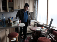 A man is standing inside the damaged apartment of Anatolii Luchok after the residential building at 4A Ostafiia Dashkevycha Street was struc...