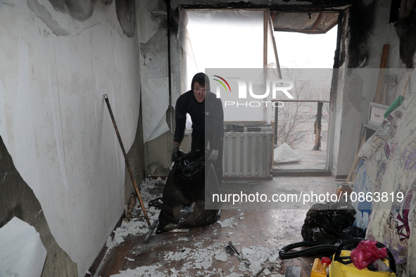 A man is picking up rubble in the apartment of Anatolii Luchok, which was damaged after the residential building at 4A Ostafiia Dashkevycha...