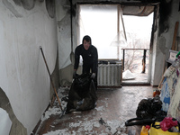 A man is picking up rubble in the apartment of Anatolii Luchok, which was damaged after the residential building at 4A Ostafiia Dashkevycha...