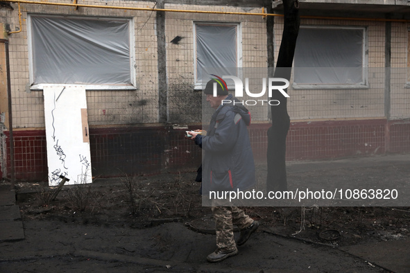 A man is carrying a plastic plate in the yard outside the residential building at 4A Ostafiia Dashkevycha Street in Kyiv, Ukraine, on Decemb...