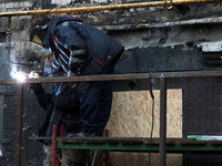 A welder is working on the residential building at 4A Ostafiia Dashkevycha Street in Kyiv, Ukraine, on December 18, 2023, which was damaged...