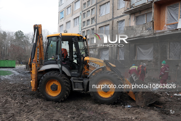 Municipal workers are using a bucket loader to remove rubble outside the residential building at 4A Ostafiia Dashkevycha Street, which was d...