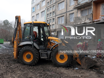 Municipal workers are using a bucket loader to remove rubble outside the residential building at 4A Ostafiia Dashkevycha Street, which was d...