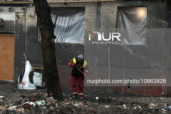 A municipal worker is cleaning away the rubble outside the residential building at 4A Ostafiia Dashkevycha Street, which was damaged by the...