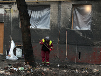 A municipal worker is cleaning away the rubble outside the residential building at 4A Ostafiia Dashkevycha Street, which was damaged by the...