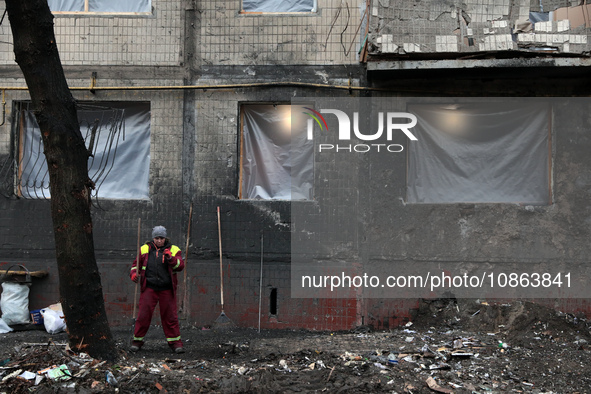 A municipal worker is cleaning away the rubble outside the residential building at 4A Ostafiia Dashkevycha Street, which was damaged by the...