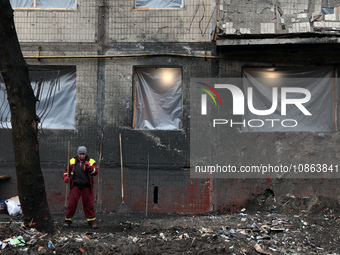 A municipal worker is cleaning away the rubble outside the residential building at 4A Ostafiia Dashkevycha Street, which was damaged by the...