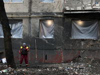 A municipal worker is cleaning away the rubble outside the residential building at 4A Ostafiia Dashkevycha Street, which was damaged by the...