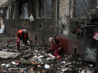 Municipal workers are removing the rubble outside the residential building at 4A Ostafiia Dashkevycha Street, which was damaged by the debri...