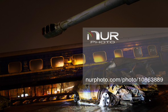 A wrecked car is being displayed in front of the Ukrzaliznytsia (Ukrainian Railways) train carriage, which was used for the evacuation of ci...