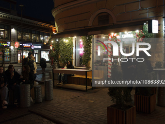 Visitors are staying at an outdoor space of a cafe at night in Kyiv, Ukraine, on December 18, 2023. (