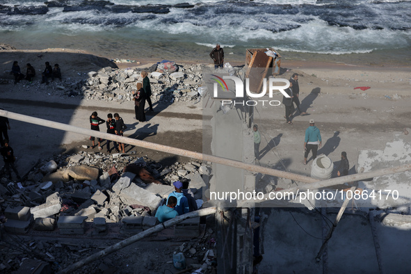 Palestinians are gathering amid the rubble of destroyed buildings following an Israeli bombardment in Deir El-Balah, in the central Gaza Str...