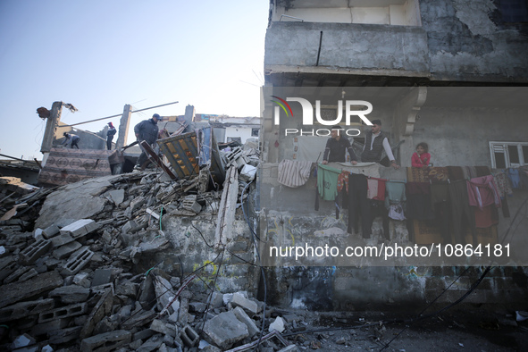 Palestinians are gathering amid the rubble of destroyed buildings following an Israeli bombardment in Deir El-Balah, in the central Gaza Str...