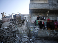 Palestinians are gathering amid the rubble of destroyed buildings following an Israeli bombardment in Deir El-Balah, in the central Gaza Str...