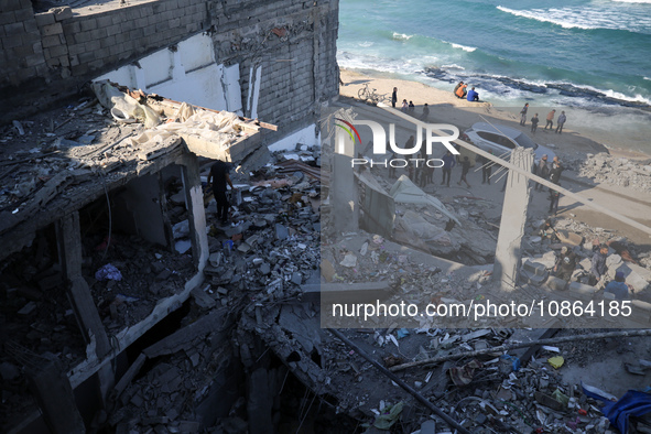 Palestinians are gathering amid the rubble of destroyed buildings following an Israeli bombardment in Deir El-Balah, in the central Gaza Str...