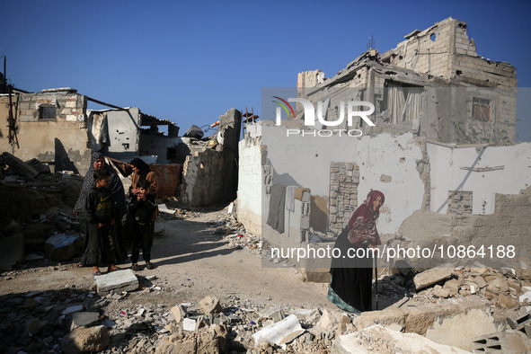 Palestinians are gathering amid the rubble of destroyed buildings following an Israeli bombardment in Deir El-Balah, in the central Gaza Str...