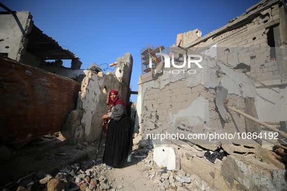 Palestinians are gathering amid the rubble of destroyed buildings following an Israeli bombardment in Deir El-Balah, in the central Gaza Str...