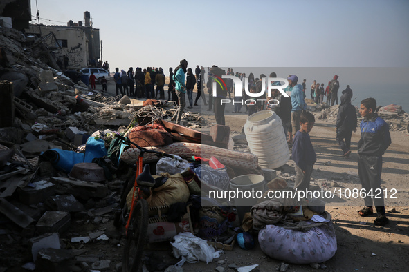 Palestinians are gathering amid the rubble of destroyed buildings following an Israeli bombardment in Deir El-Balah, in the central Gaza Str...