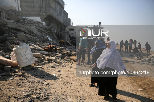 Palestinians are gathering amid the rubble of destroyed buildings following an Israeli bombardment in Deir El-Balah, in the central Gaza Str...