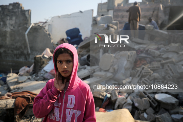 Palestinians are gathering amid the rubble of destroyed buildings following an Israeli bombardment in Deir El-Balah, in the central Gaza Str...