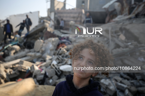 Palestinians are gathering amid the rubble of destroyed buildings following an Israeli bombardment in Deir El-Balah, in the central Gaza Str...