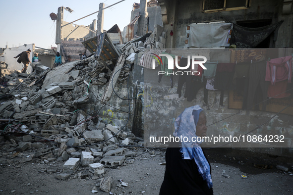 Palestinians are gathering amid the rubble of destroyed buildings following an Israeli bombardment in Deir El-Balah, in the central Gaza Str...