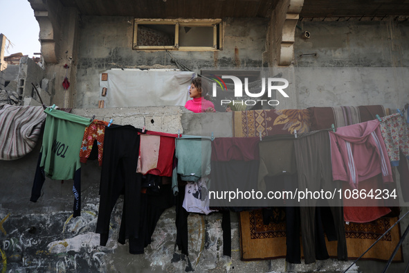 Palestinians are looking at the rubble of destroyed buildings following an Israeli bombing in Deir al-Balah, in the central Gaza Strip, on D...