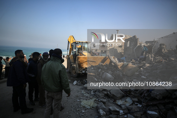 Palestinians are gathering amid the rubble of destroyed buildings following an Israeli bombardment in Deir El-Balah, in the central Gaza Str...