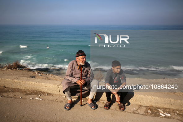 Palestinians are looking at the rubble of destroyed buildings following an Israeli bombing in Deir al-Balah, in the central Gaza Strip, on D...