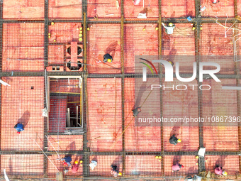 Workers are braving the cold to carry out steel binding operations at the construction site of the Fuxi Street Phase II project in Moganshan...