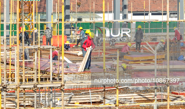 Workers are braving the cold at the construction site of the second phase of the Fuxi Street project in Moganshan town, Deqing County, Huzho...