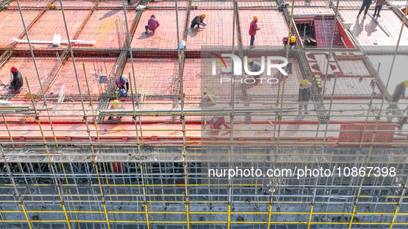 Workers are braving the cold to carry out steel binding operations at the construction site of the Fuxi Street Phase II project in Moganshan...