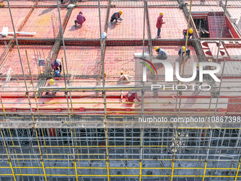 Workers are braving the cold to carry out steel binding operations at the construction site of the Fuxi Street Phase II project in Moganshan...