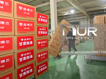 A staff member at a down jacket manufacturer is hauling down jackets to support the quake-hit areas of Jishishan County in Qingzhou, Shandon...