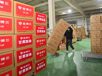 A staff member at a down jacket manufacturer is hauling down jackets to support the quake-hit areas of Jishishan County in Qingzhou, Shandon...