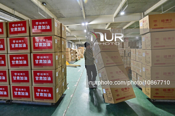 A staff member at a down jacket manufacturer is hauling down jackets to support the quake-hit areas of Jishishan County in Qingzhou, Shandon...